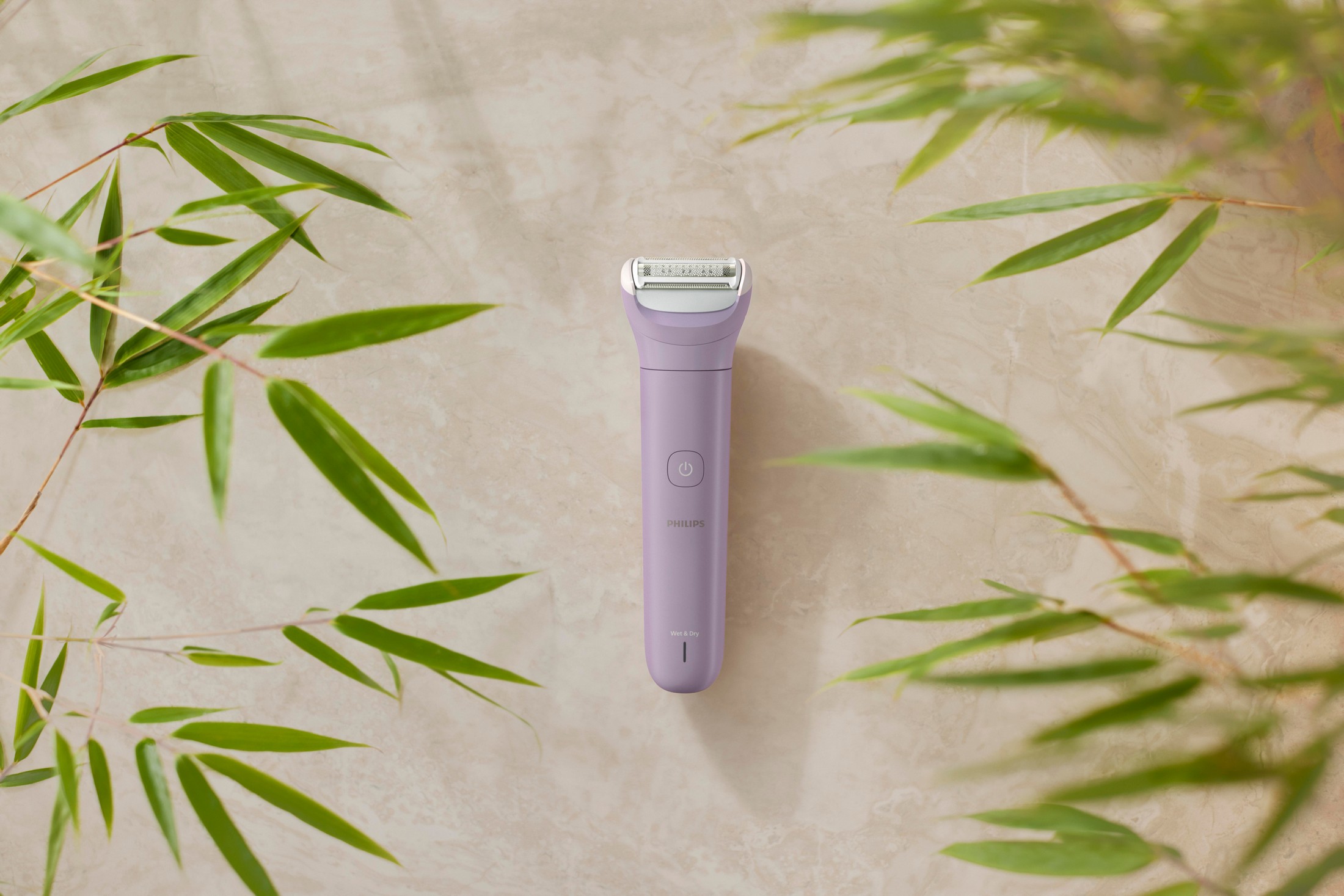 Philips BRL114/00 dámský holicí strojek - holicí strojek Philips na podkladu se zelenými listy